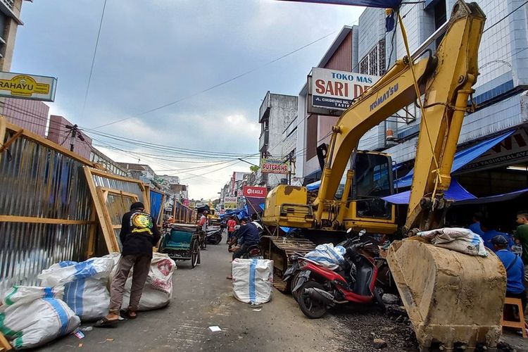 Para PKL Cihideung, Kota Tasikmalaya, Jawa Barat, harus berpindah-pindah lapak dengan mengangkut dangannya pakai karung besar saat terganggu oleh pengerjaan alat berat proyek Maliboro-nya Tasikmalaya di Jalan HZ Mustofa dan Cihideung, Kamis (21/7/2022).