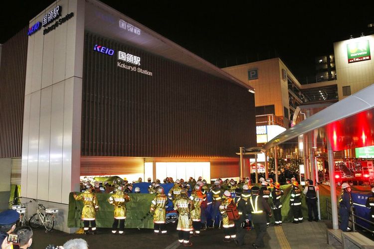 Pekerja darurat dan petugas polisi di tempat kejadian di stasiun kereta api di Tokyo, Minggu 31 Oktober 2021 setelah seorang pria mengacungkan pisau di kereta komuter menikam beberapa penumpang sebelum menyalakan api, yang membuat orang-orang berebut untuk melarikan diri dan melompat dari jendela, kata polisi dan saksi.