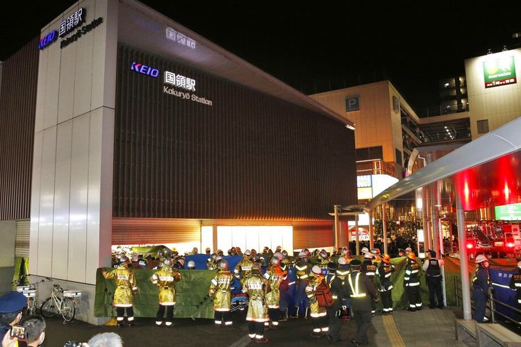 Pekerja darurat dan petugas polisi di tempat kejadian di stasiun kereta api di Tokyo, Jepang, Minggu 31 Oktober 2021 setelah seorang pria mengacungkan pisau di kereta komuter menikam beberapa penumpang sebelum menyalakan api, yang membuat orang-orang berebut untuk melarikan diri dan melompat dari jendela, kata polisi dan saksi.