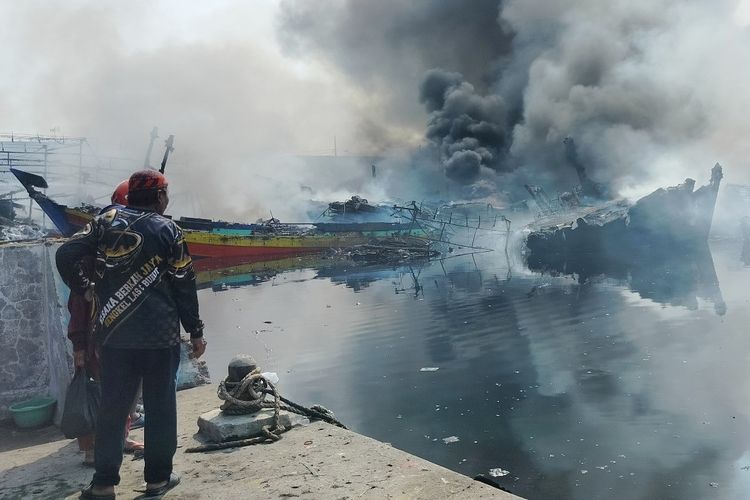 Kepulan asap hitam masih terlihat di sejumlah kapal yang terbakar di Pelabuhan Jongor Kota Tegal, Jawa Tengah, Selasa (15/8/2023). Dalam kebakaran yang terjadi sejak Senin (14/8/2023) malam dilaporkan menghanguskan sampai 52 kapal nelayan yang sedang bersandar.