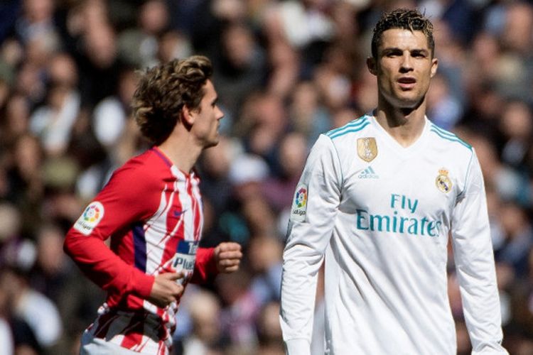 Penyerang Atletico Madrid, Antoine Griezmann (kiri), berlari melewati megabintang Real Madrid, Cristiano Ronaldo, dalam laga Liga Spanyol di Stadion Santiago Bernabeu, Madrid pada 8 April 2018.
