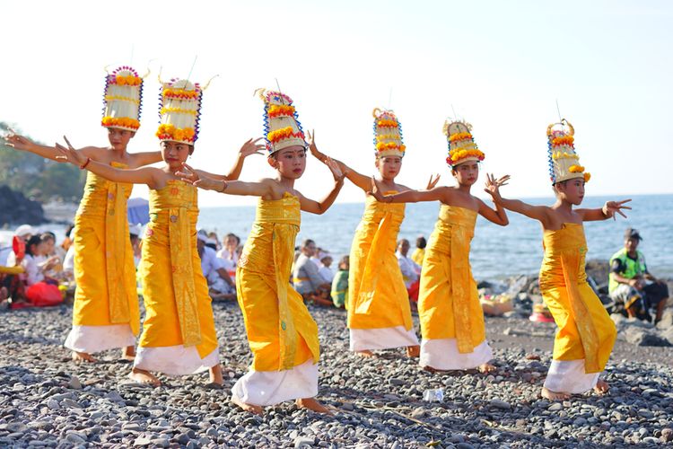 Buleleng, Indonesia - October 13, 2019: a group of teenage dancers who are dancing the janger dance on the edge of the beach in the context of mass ngaben on ponjok batu beach, Bali Province, Indonesi