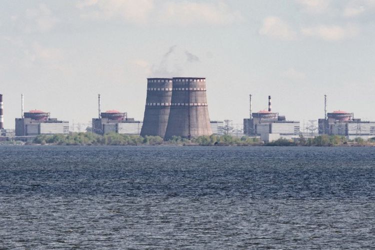 Foto yang diambil pada 27 April 2022 ini menunjukkan pemandangan pembangkit listrik tenaga nuklir atau PLTN Zaporizhzhia, yang terletak di daerah Enerhodar yang dikuasai Rusia, dilihat dari Nikopol. 