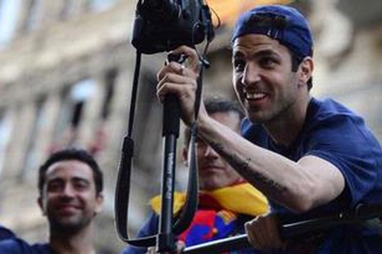 Cesc Fabregas sedang mengambil gambar momen ketika Barcelona melakukan parade keberhasilan mereka menjuarai La Liga musim 2013.