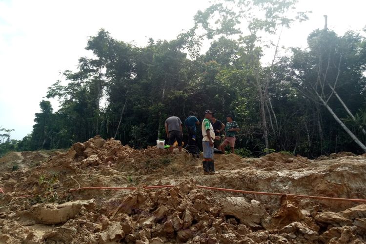 Para pekerja pembangunan Proyek Palapa Ring Paket Timur sedang memperbaiki jaringan kabel serat optic yang putus akibat kerap terlindas alat berat di ruas jalan Nasional Memey-Ransiki.