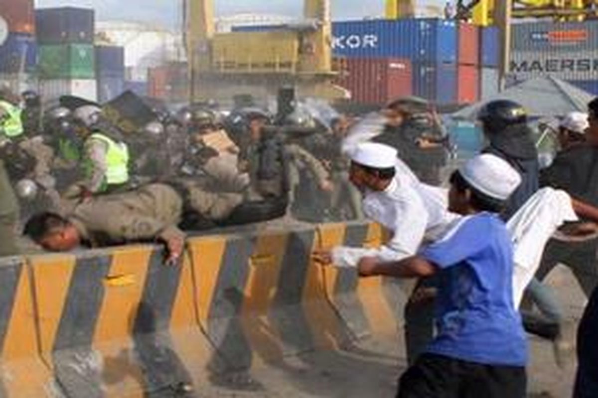 Massa bentrok dengan Satpol PP dan Kepolisian Resort Jakarta Utara yang berupaya membongkar gapura kompleks makam Mbah Priok di Koja, Jakarta Utara, Rabu (14/4/2010). Bentrokan ini mengakibatkan sedikitnya 100 orang terluka dan belasan kendaraan roda dua dan empat dibakar massa. 