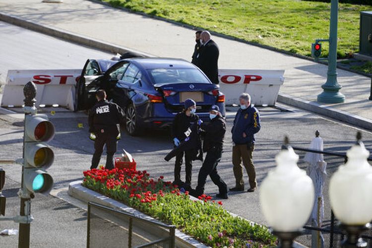 Pihak berwenang menyelidiki tempat kejadian perkara (TKP) setelah seorang pria menabrakkan mobil ke dua petugas dan barikade di Capitol Hill, Washington DC, AS pada Jumat (2/4/2021). 