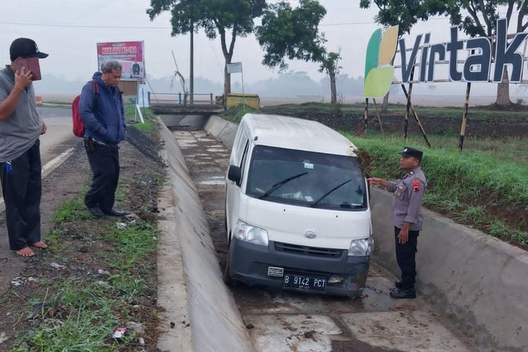 Polisi mengevakuasi mobil Daihatsu Gran Max warna putih  bernomor polisi B-9142-PCT yang ditinggalkan pengemudinya di saluran irigasi Desa Senon, Kecamatan Kemangkon, Purbalingga, Jawa Tengah, Rabu (22/11/2023) pagi.