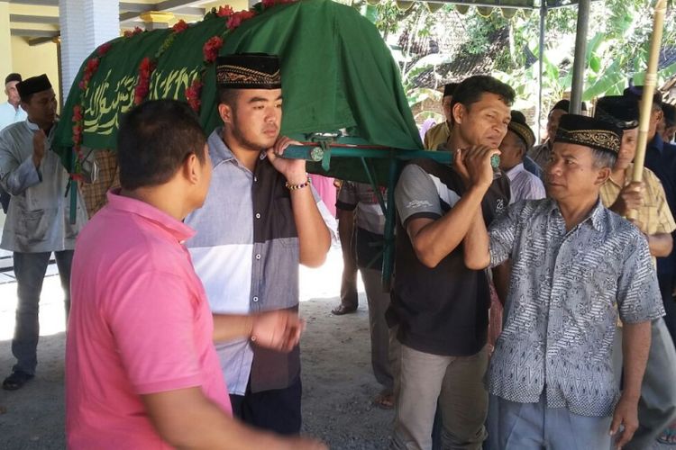 Keluarga dan warga memakamkan jenazah Jemani, Tenaga Kerja Indonesia asal Desa Ngumpul, Kecamatan Balong, Kabupaten Ponorogo yang meninggal di Malaysia di tempat pemakaman umum di kampung halamannya, Jumat ( 15/9/2017).