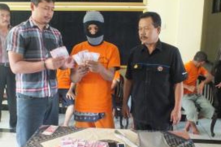 Bernard Ronaldo Lamury (tengah), warga Semarang, diperiksa petugas Polres Magelang karena diduga hendak mengedarkan uang palsu senilai Rp 7,8 juta, Senin (31/3/2015).