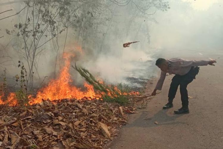 Sejumlah anggota polisi berusaha memadamkan kebakaran hutan di Desa Adaut, Kecamatan Selaru, Kabupaten Kepulauan Tanimbar, Maluku, Senin (20/11/2023)