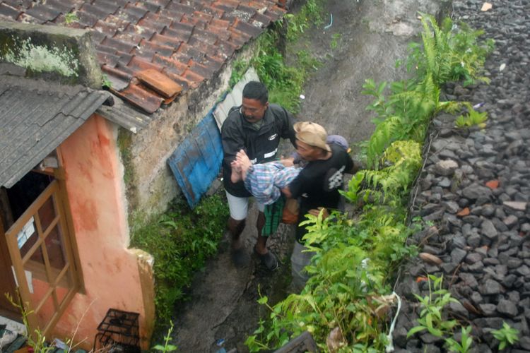 Dua warga mengevakuasi Suganda (60) yang menderita stroke di Kelurahan Benteng, Kecamatan Warudoyong, Kota Sukabumi, Jawa Barat, Selasa (11/4/2017). 