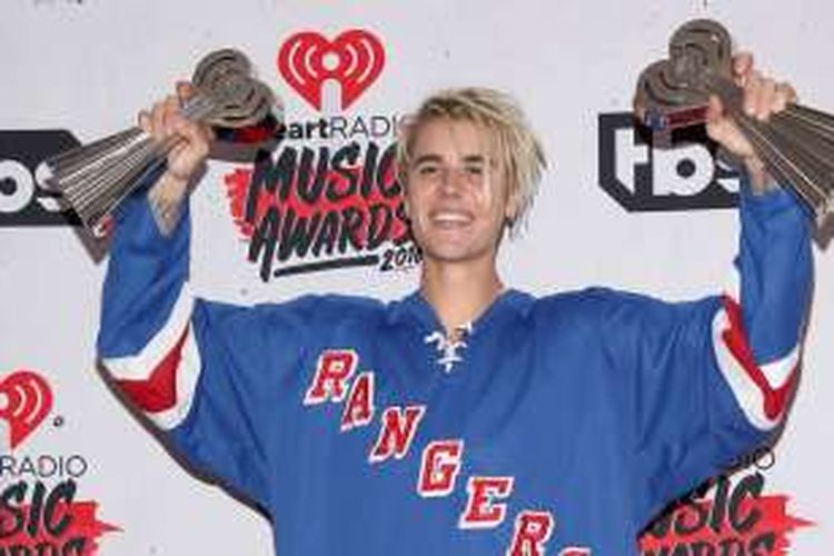 Justin Bieber berpose bersama dua penghargaan Best New Artist dan Best Dance Song, pada acara iHeartRadio Music Awards di The Forum, Inglewood, California, Minggu (3/4/2016).
