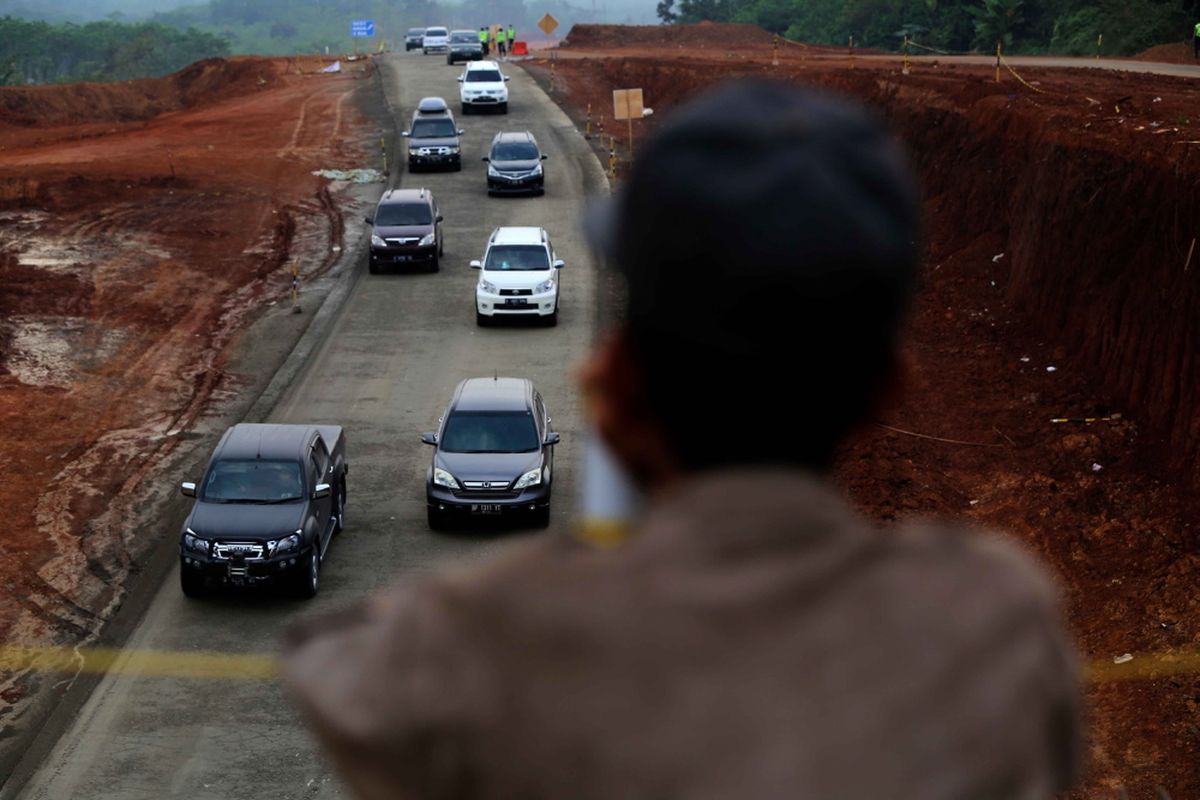 Warga menonton suasana pemudik melintasi jalan tol darurat Brebes Timur dan Pemalang-Batang di Batang, Jawa Tengah, Kamis (22/6/2017). Mulai Kamis malam ini (22/6/2017) jalan tol darurat Brebes Timur-Pemalang-Batang dibuka selama 24 jam.