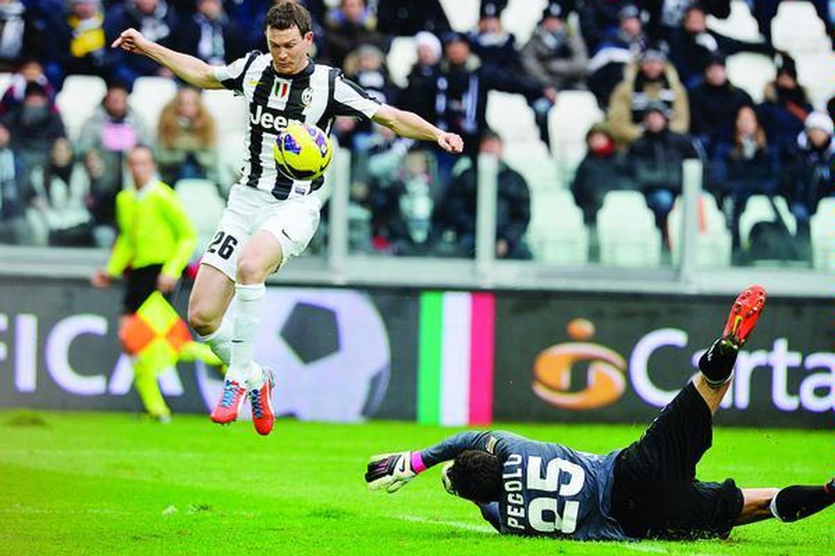 Kapten Juventus, Stephan Lichtsteiner (kiri), mencetak gol pertama saat timnya melawan Siena di Liga Italia, Minggu (24/2), di Turin.  Juventus menang 3-0.