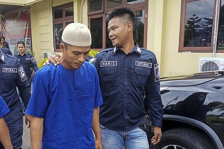 Heris (29) pelaku pembunuhan petani saat berada di Polres Musi Rawas, Sumatera Selatan. Motif pembunuhan itu ternyata dilatar belakangi pelaku dituduh sebagai pembocor informasi bahwa korban telah berselingkuh dengan istri orang hingga menyebabkannya didenda Rp 5 juta oleh pihak desa.