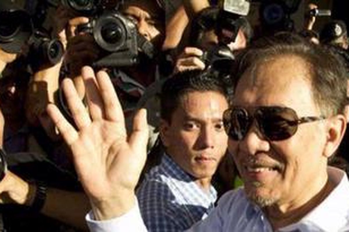 Pemimpin oposisi Malaysia Anwar Ibrahim menyambut suporternya usai dinyatakan tidak bersalah dan bebas murni di Pengadilan Tinggi Kuala Lumpur, Senin (9/1/2012) lalu.