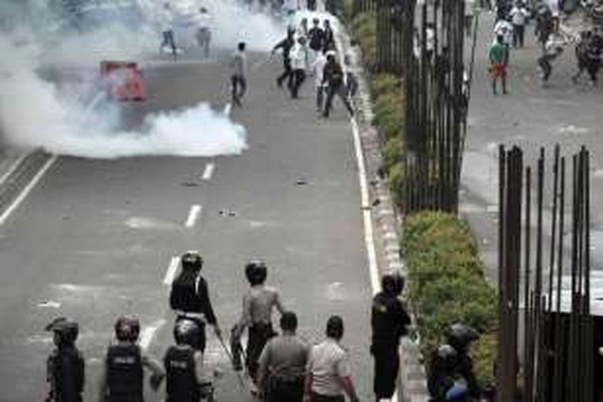 Massa demonstran berlarian menghindari tembakan gas air mata saat terjadi bentrokan dengan polisi di depan kantor KPK, Jakarta, Jumat (20/5/2016). Bentrokan terjadi saat massa dari Aliansi Masyarakat Jakarta Utara mendesak masuk ke gedung KPK untuk mendesak pemeriksaan terhadap Gubernur DKI Jakarta Basuki Tjahaja Purnama (Ahok).