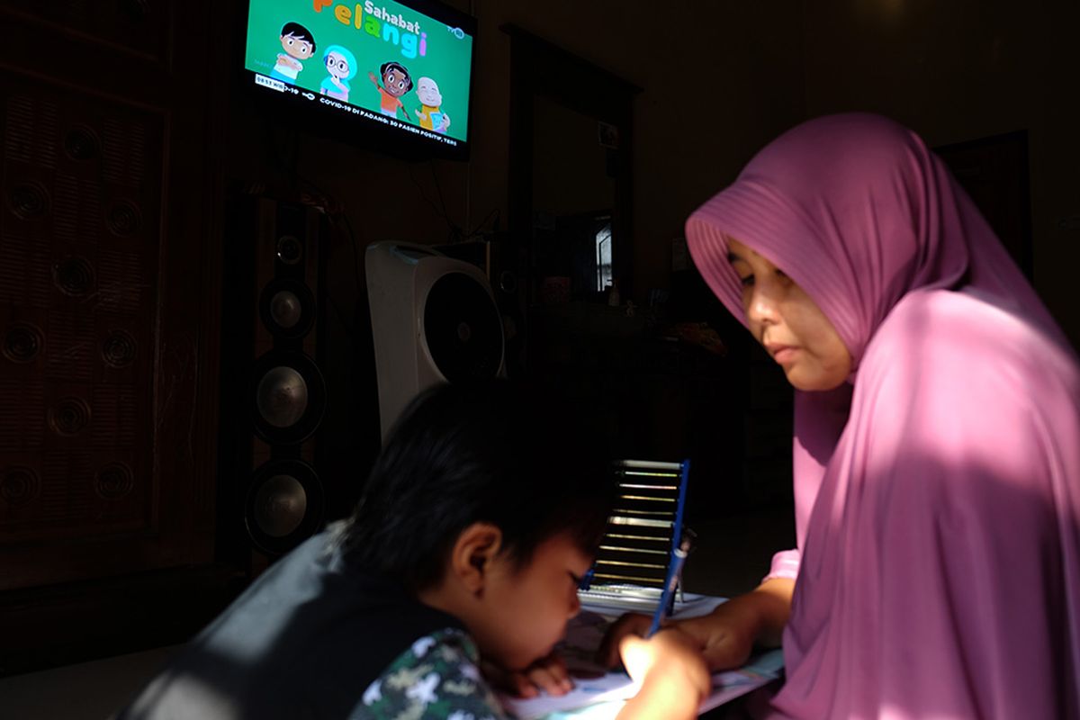 Seorang anak didampingi ibunya belajar dengan melihat tayangan siaran TVRI di rumah mereka, di Deli Serdang, Sumatera Utara, Senin (13/4/2020). Kementerian Pendidikan dan Kebudayaan bekerja sama dengan lembaga penyiaran publik TVRI sejak Senin (13/4) hingga tiga bulan ke depan menyiarkan program belajar bagi siswa mulai dari tingkat pendidikan anak usia dini (PAUD) hingga SMA guna membantu para siswa belajar di rumah selama wabah COVID-19.