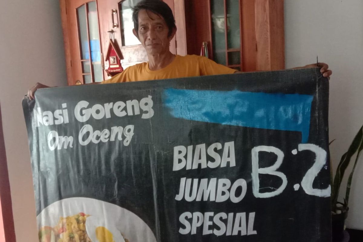 Pedagang nasi goreng babi, Bambang Dwi Priyanto (65) menunjukkan spanduk jualannya yang terdapat keterangan B2 pada Rabu (22/3/2023) di rumahnya, Jalan Bandulan Gang 6, Kota Malang. 