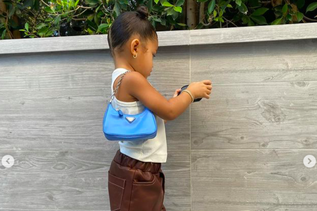 Stormi Webster putri dari Kylie Jenner dan Travis Scott berpose dengan menggunakan Prada Mini Sport seharga Rp 19 jutaan.