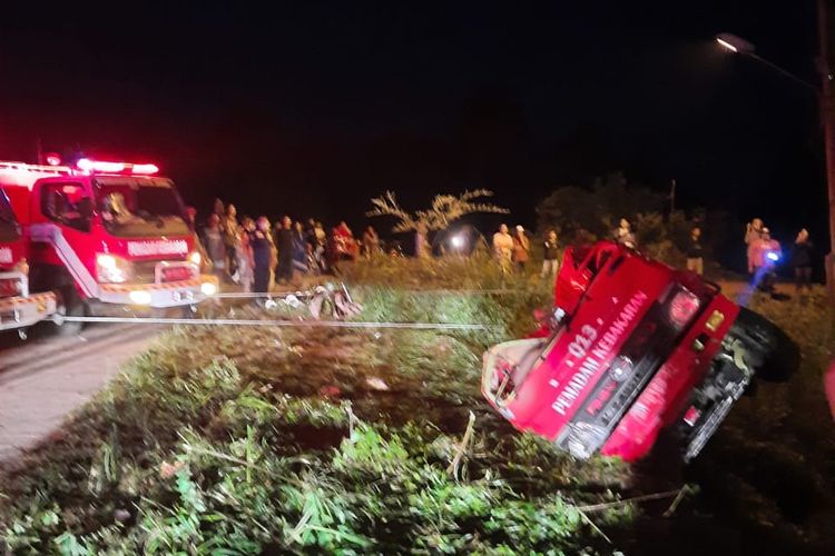 Petugas saat mengevakuasi mobil Damkar yang terbalik 