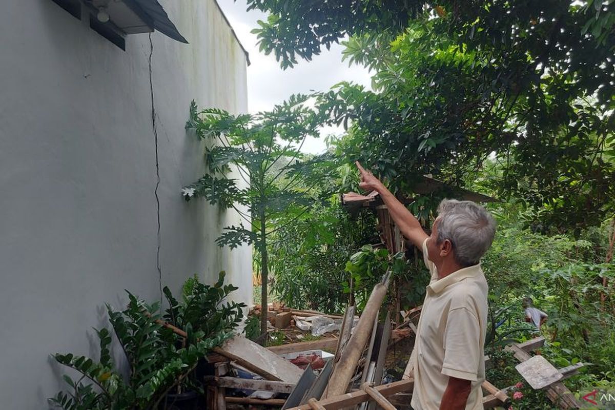 Pemilik rumah menunjukkan bagian kerusakan akibat turap Kali Cilangkap longsor di Cipayung, Jakarta, Kamis (29/12/2022). 