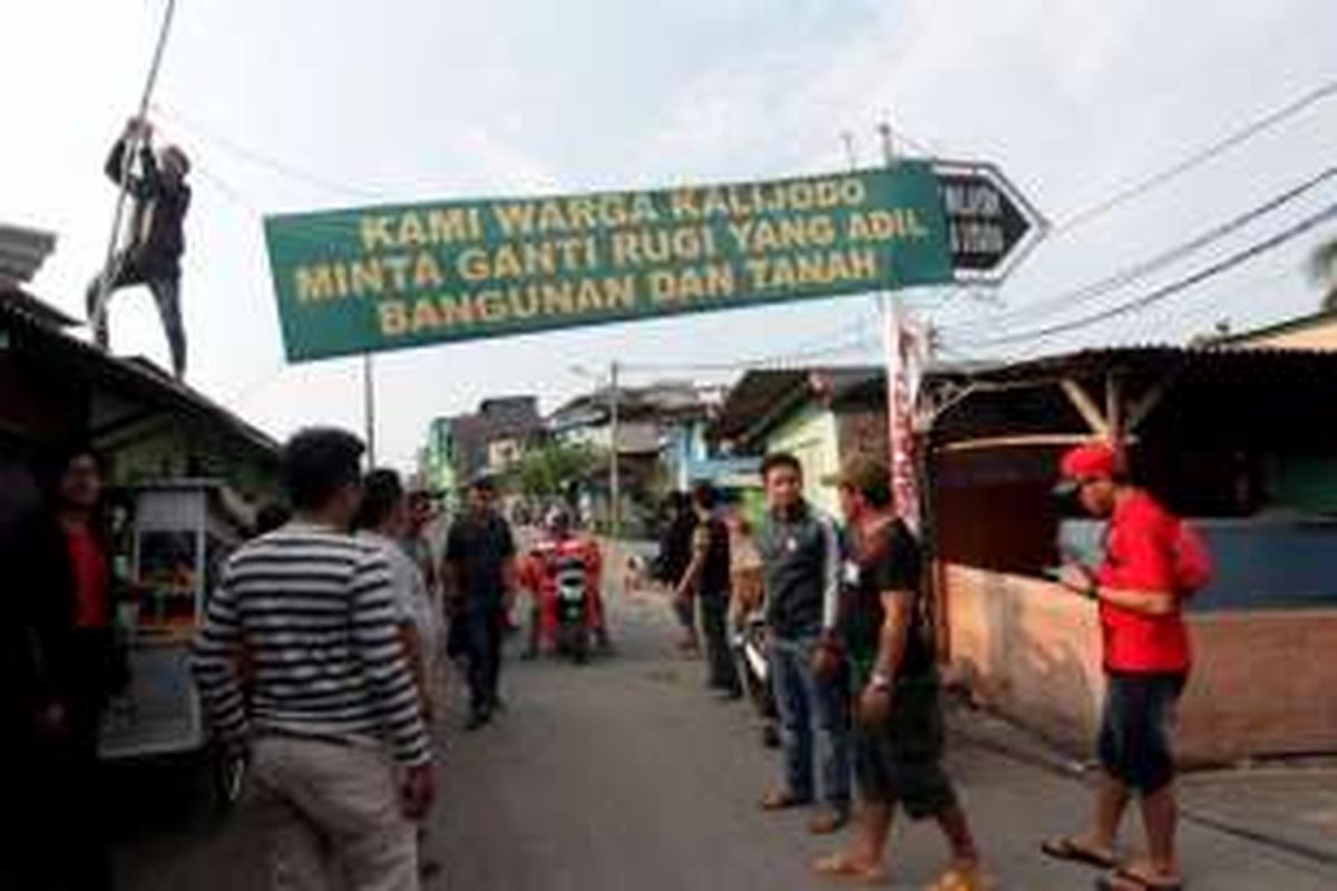 Warga yang tinggal di kawasan Kalijodo, Kelurahan Penjagalan, Kecamatan Penjaringan, Jakarta Utara, memasang spanduk tuntutan ganti rugi, Kamis (18/2/2016).