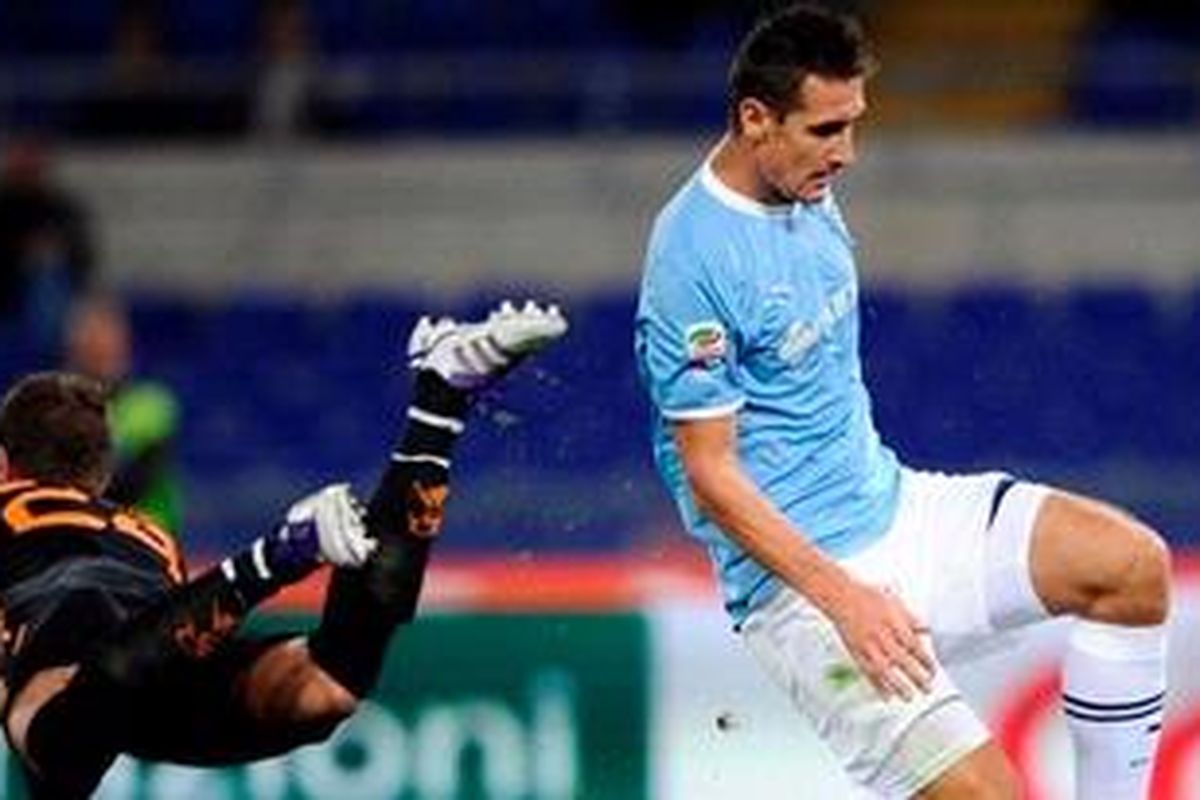 Kiper AS Roma, Maarten Stekelenburg (kiri) berdual dengan striker Lazio, Miroslav Klose, pada lanjutan Liga Serie-A, Minggu atau Senin (17/10/2011) dini hari WIB. Klose akhirnya mencetak gol kemenangan 2-1 bagi Lazio.
