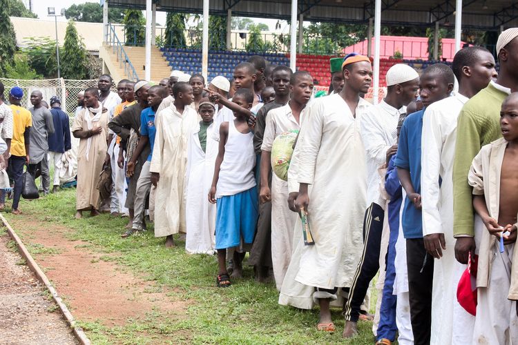 Para murid sebuah sekolah asrama keagamaan berbaris untuk makanan dan perawatan di Stadion Ahmadu Bello di Kaduna, utara Nigeria, pada 27 September 2019. Polisi Kaduna menyelamatkan anak-anak itu setelah mereka menjadi korban penyiksaan sekolah keagamaan tersebut.