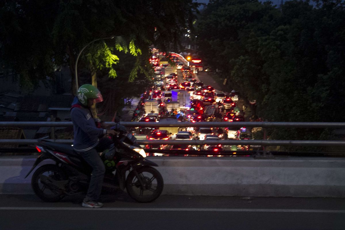 Pengendara berhenti dengan latar belakang kemacetan di ruas Jalan Raya Pasar Minggu, Jakarta Selatan, Rabu, (18/12/2019). Kemacetan panjang hingga lenteng agung akibat pembangunan fly over Lenteng Agung.