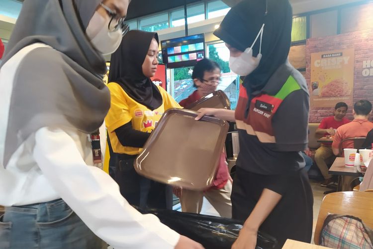 Petugas di Burger King, Cilandak KKO, Jakarta Selatan (12/5/2023), mengambil makanan sisa dari pelanggan yang tandang dan makan di tempat.
