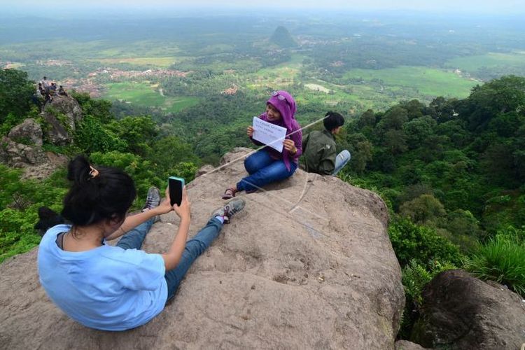 Pengunjung menikmati pemandangan alam dari Gunung Munara yang terletak di Kampung Sawah, Rumpin, Kabupaten Bogor, Jabar, Sabtu (7/2). Gunung Munara yang memiliki ketinggian sekitar 300 mdpl tersebut menjadi alternatif tujuan wisata para pegiat alam bebas di Bogor sekaligus jika mencari wisata gunung dekat Jakarta. (ANTARA FOTO/Jafkhairi).