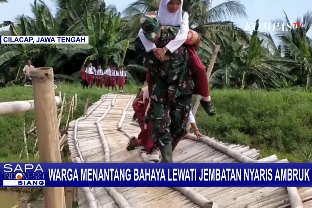 Tangkapan layar sebuah tayangan video menampilkan seorang anggota TNI menggendong seorang siswa SD melewati jembatan bambu hampir ambruk di Cilacap, Jawa Tengah.