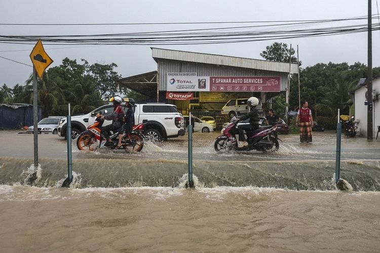 Orang-orang berkendara melewati daerah yang terendam banjir setelah banjir bandang di Shah Alam, dekat Kuala Lumpur, pada 3 Oktober. Kuala Lumpur Malaysia dilaporkan dilanda hujan besar lagi pada Selasa (15/10/2024).