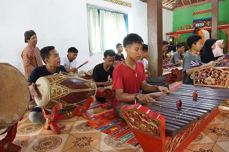Pengunjung berlatih alat musik gamelan di Desa Wisata Pentingsari.