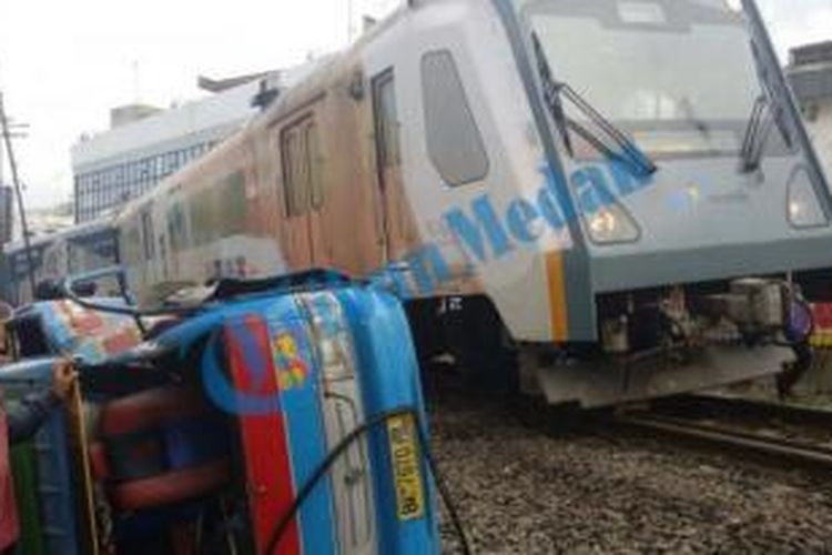 Sebuah angkutan kota  terseret sejauh 50 meter setelah ditabrak kereta api jurusan Tanjungbalai-Kota Medan yang melintas di Rel Kereta yang berada di Jalan Sisingamangaraja, Medan, Rabu (25/11/2015) 