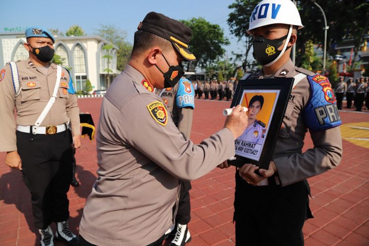 Kapolres Gresik AKBP Mochamad Nur Azis (kiri), saat menandai foto Bripka Deni Rahmat dengan tinta merah sebagai tanda Pemberhentian Tidak Dengan Hormat (PTDH), Senin (29/8/2022).