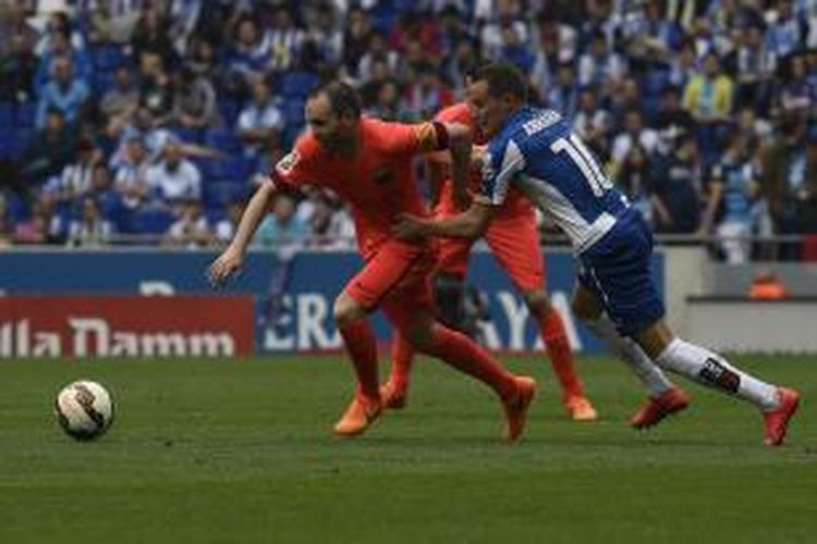 Gelandang Barcelona Andres Iniesta (kiri) berebut bola dengan gelandang Espanyol Abraham, pada pertandingan Primera Division, di Cornella El Prat, Sabtu (25/4/2015). Laga itu berakhir 2-0 untuk Barcelona.