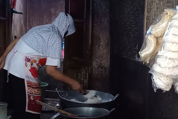 Salah satu pegawai Kicak, Mbah Wono saat memasak/menyangrai parutan kelapa dengan menggunakan tungku arang di Kota Yogyakarta, Rabu (13/4/2022).