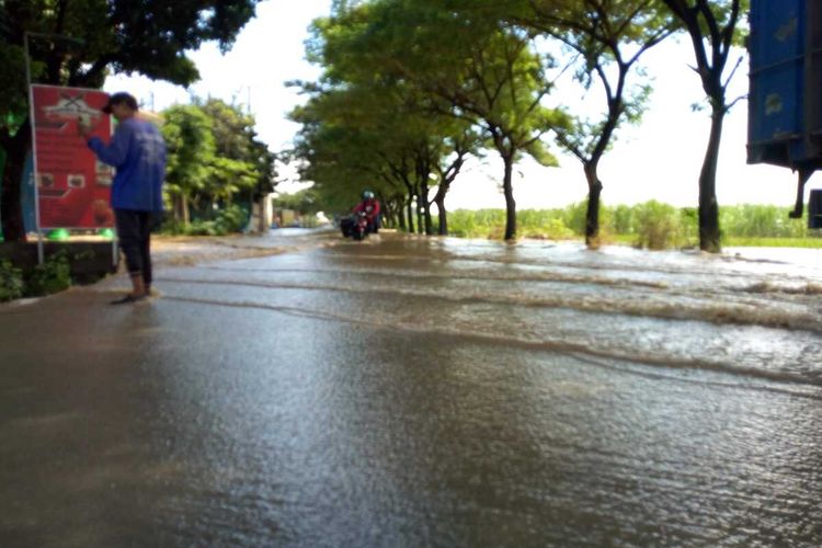Kondisi jalan penghubung Kabupaten Jombang dengan Kabupaten Kediri tergenang banjir akibat jebolnya tanggul Sungai Konto, di Desa Wangkalkepuh, Kecamatan Gudo, Kabupaten Jombang, Jawa Timur, Rabu (1/3/2023).