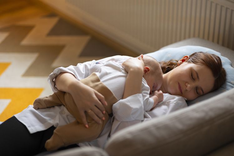 Ilustrasi ibu baru tidur yang cukup untuk mengurangi stres.