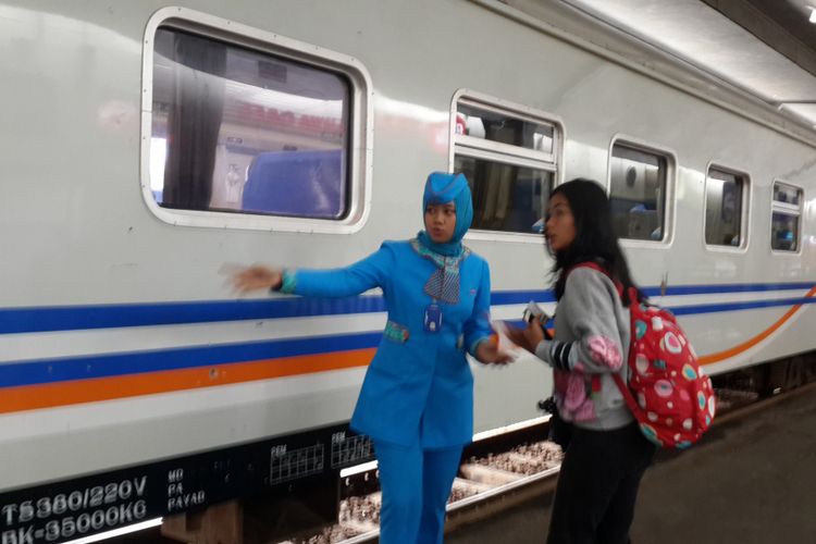 Seorang pramugari Kereta Api (KA) di Stasiun Kota Malang saat melayani penumpang, Kamis (14/12/2017)