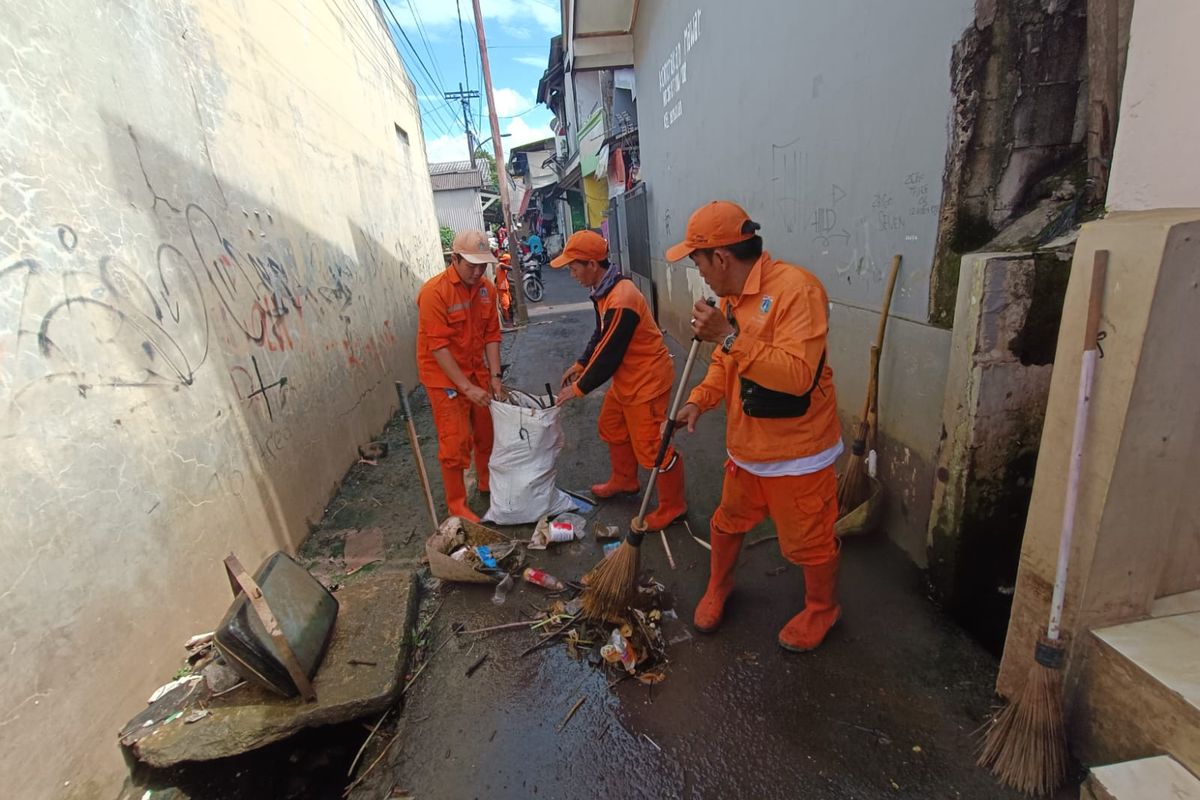 Petugas PPSU Kelurahan Kampung Rambutan membersihkan berbagai jenis sampah pascabanjir di Kawasan RT 04 dan RT 12 RW 02, Kelurahan Kampung Rambutan, Kecamatan Ciracas, Jakarta Timur, Senin (20/2/2023).