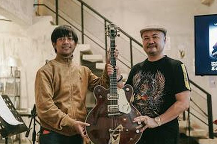 Rian D'MASIV menyerahkan gitar miliknya kepada pemenang lelang, Basuki Surodjo atau Cobaz.