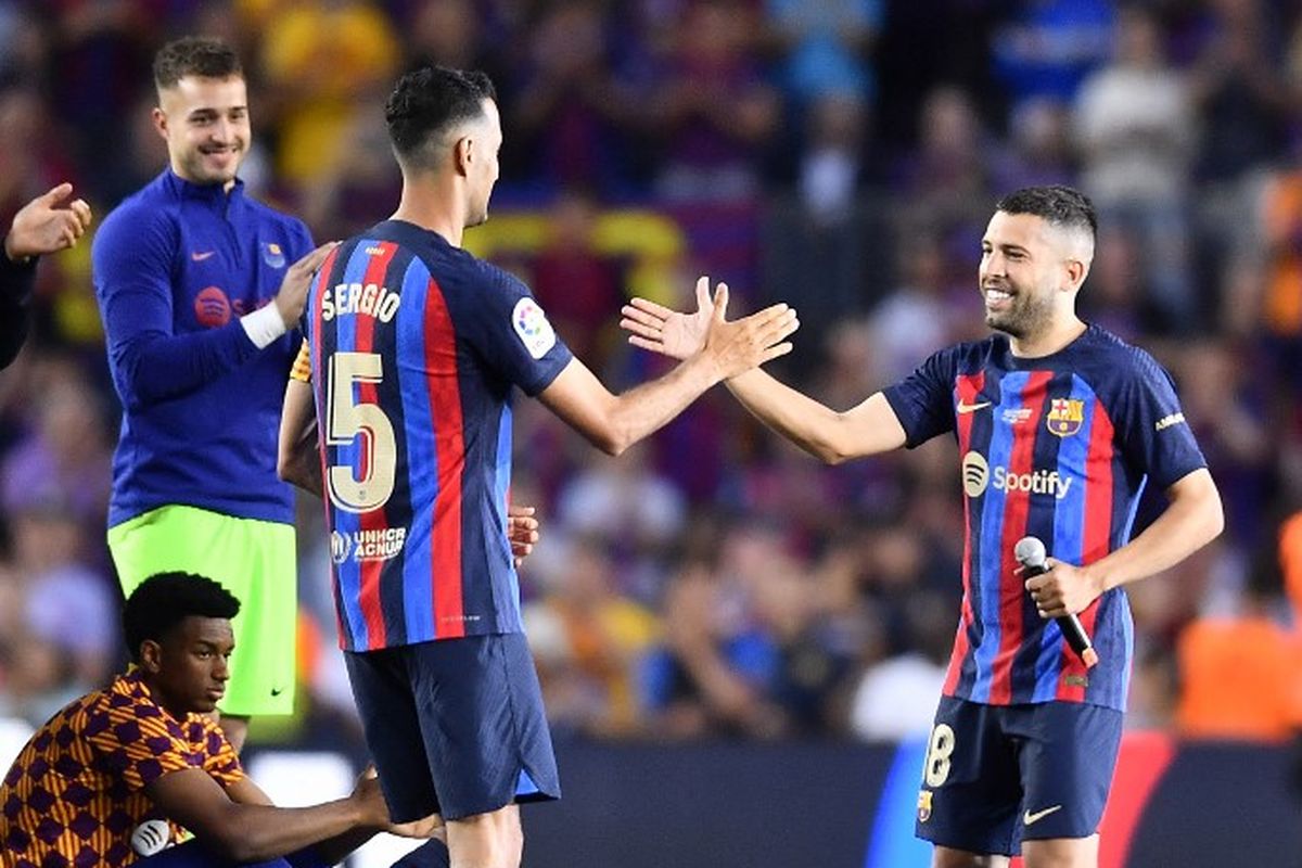 Sergio Busquets dan Jordi Alba berjabat tangan saat memberikan salam perpisahan seusai laga Barcelona vs Mallorca di Stadion Camp Nou, Senin (29/5/2023) dini hari WIB. Sergio Busquets dan Jordi Alba akan meninggalkan Barcelona pada akhir musim ini. (Foto oleh Pau Barrena/AFP)