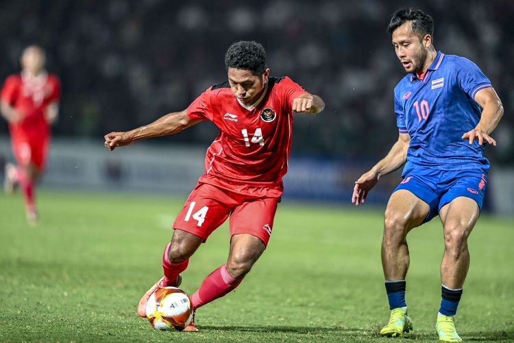 Pesepak bola Timnas Indonesia U-22 Muhammad Fajar Fathur Rachman mencoba melewati pesepak bola Thailand Achitpol Keereerom (kanan) pada final SEA Games 2023 di National Olympic Stadium, Phnom Penh, Kamboja, Selasa (16/5/2023).