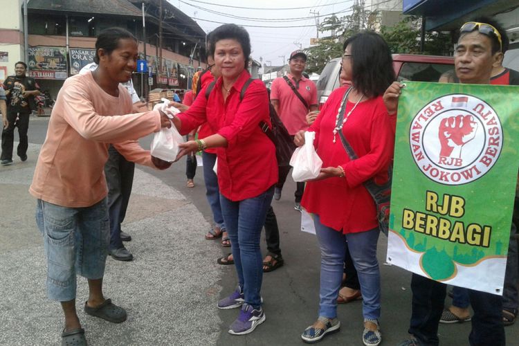 Relawan Jokowi Bersatu bagi-bagi takjil nasi kotak di kawasan Tugu Jam Pasar Gede Solo, Jawa Tengah, Minggu (20/5/2018) petang.