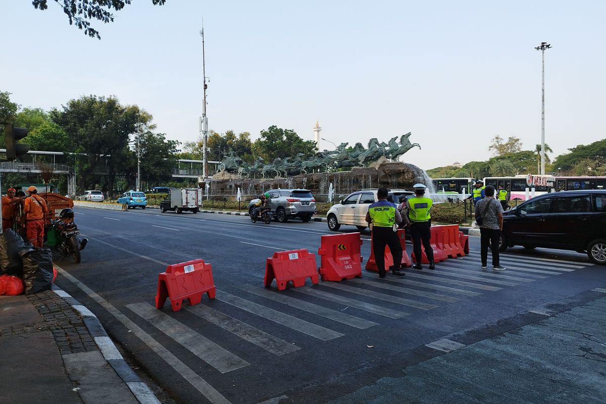 Polisi mengawasi Jalan Medan Merdeka Barat arah Harmoni di dekat Patung Kuda Arjuna Wijaya, Gambir, Jakarta Pusat, Senin (16/10/2023).