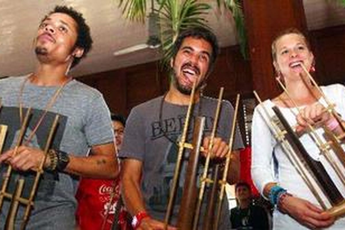 Tiga blogger, Tony Miller, Antonio Santiago dan Kelly Ferris (kiri ke kanan) memainkan alat musik tradisional Angklung pada acara Expedition 206 di kawasan Museum Fatahillah, Jakarta Barat, Selasa (4/5/2010). Mereka berkeliling ke 206 negara dengan misi mendokumentasikan semangat kegembiraan penduduk tiap negara dan menyebarkan melalui situs jejaring sosial seperti Facebook, Twitter, Flickr, Youtube dan Blog. 